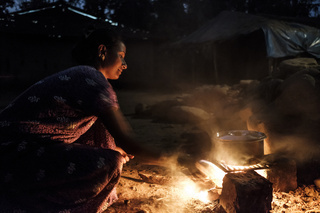 India. Maharashtra. Mumbai. Sanjay Gandhi National Park. In an Adivasi (Tribal) village inside Sanjay Gandhi National Park a women is cooking. People here live with the constant threat of leopard attacks. Sandjay Gandhi National Park has the highest density of wild Leopards in the world. © Florian Lang