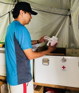 Japanese Red Cross pharmacist Yasutoro Nakazato inspects a box of medications that have just been delivered by the team to the The Bangladesh Red Crescent Society (BDRCS)/Japanese Red Cross (JRC) emergency clinic